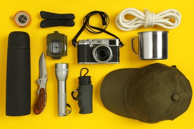 Flat lay composition with different camping equipment on yellow sleeping mat. Traveler set