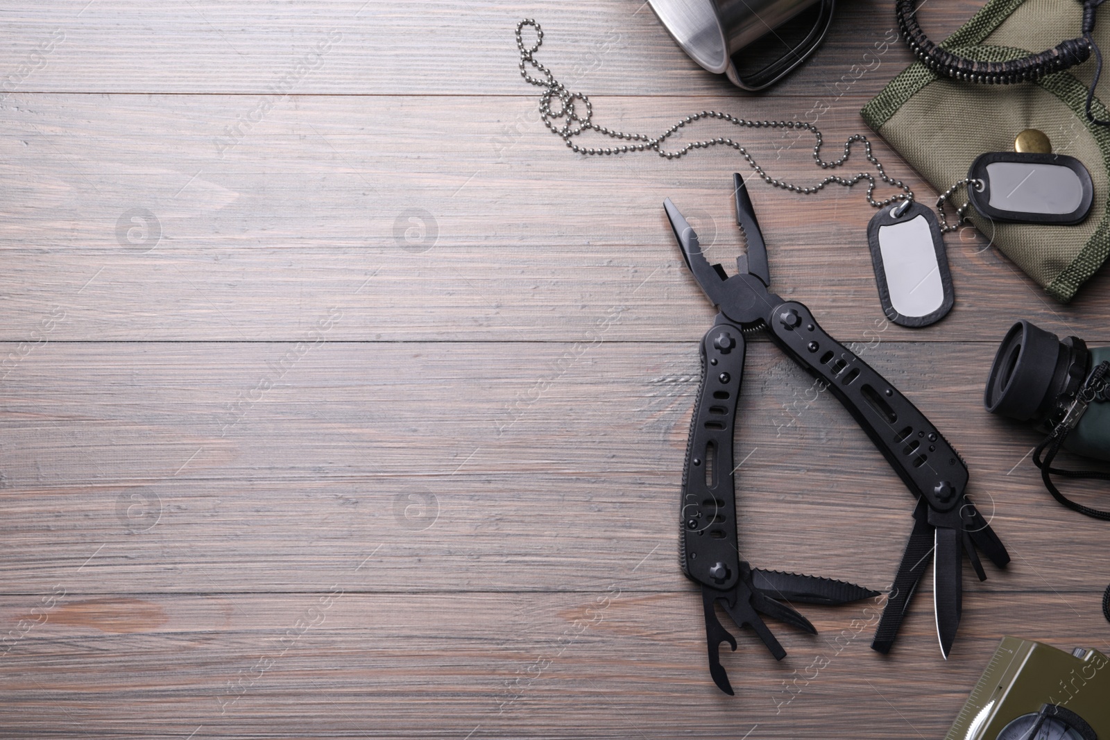 Photo of Flat lay composition with compact portable multitool and accessories on wooden table. Space for text