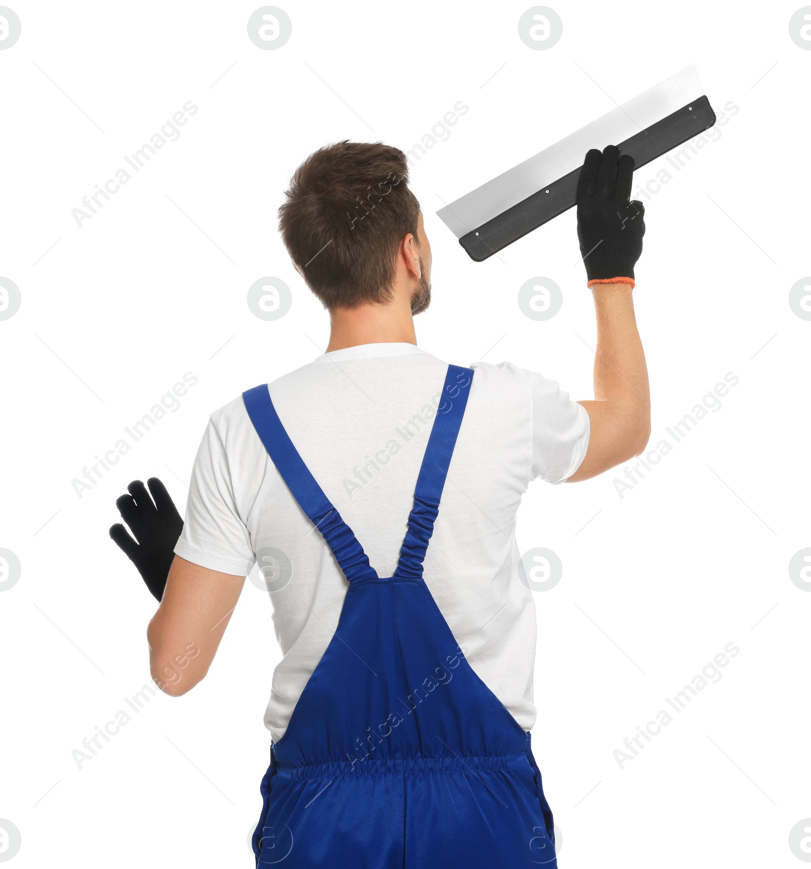 Photo of Professional worker in uniform with putty knife on white background, back view