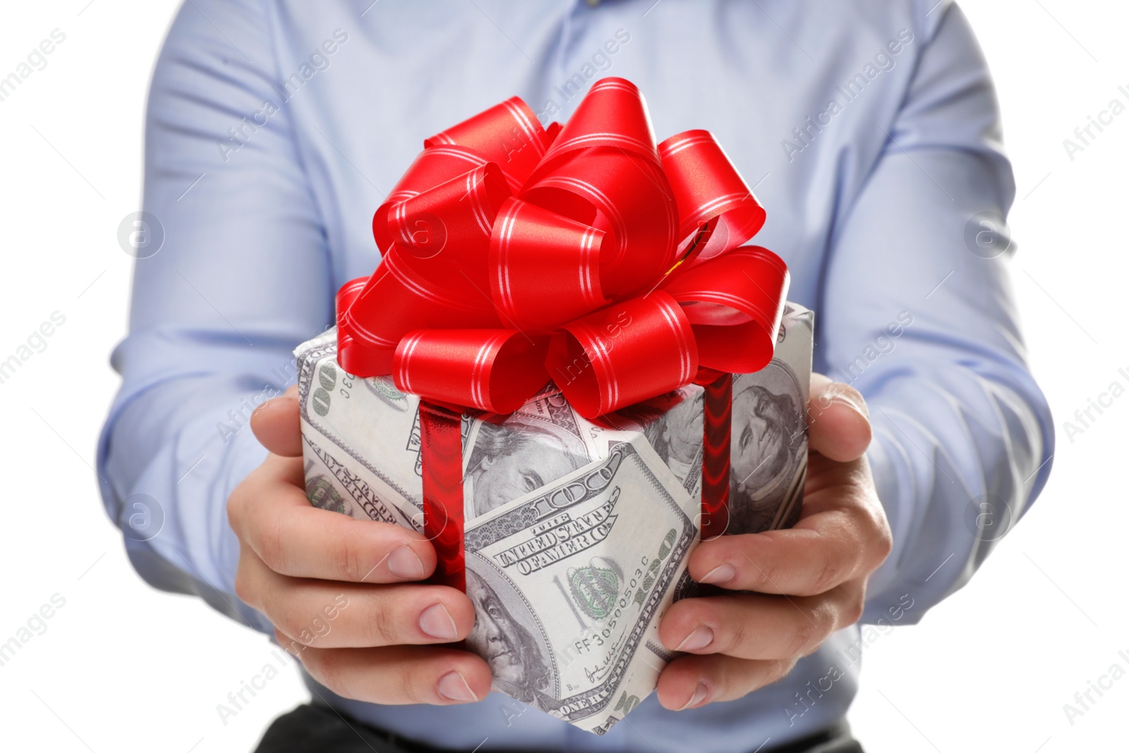 Photo of Man holding gift box wrapped in decorative paper with dollar pattern on white background, closeup