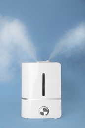 Photo of Modern air humidifier on light blue background