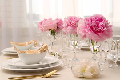 Stylish table setting with beautiful peonies and fabric napkins indoors