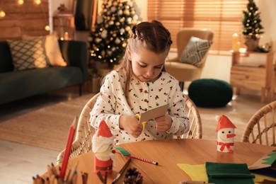 Photo of Cute child making Christmas greeting card at home