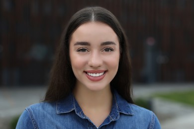 Photo of Portrait of beautiful woman outdoors. Attractive lady smiling and looking into camera