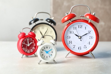 Photo of Many different alarm clocks on table. Time change concept