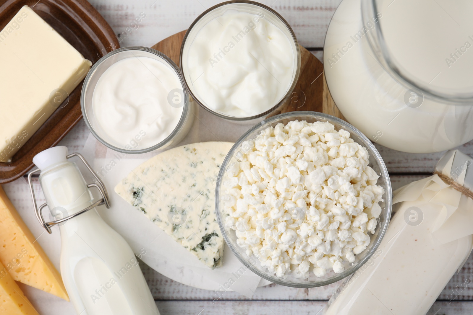 Photo of Different fresh dairy products on white wooden table, flat lay