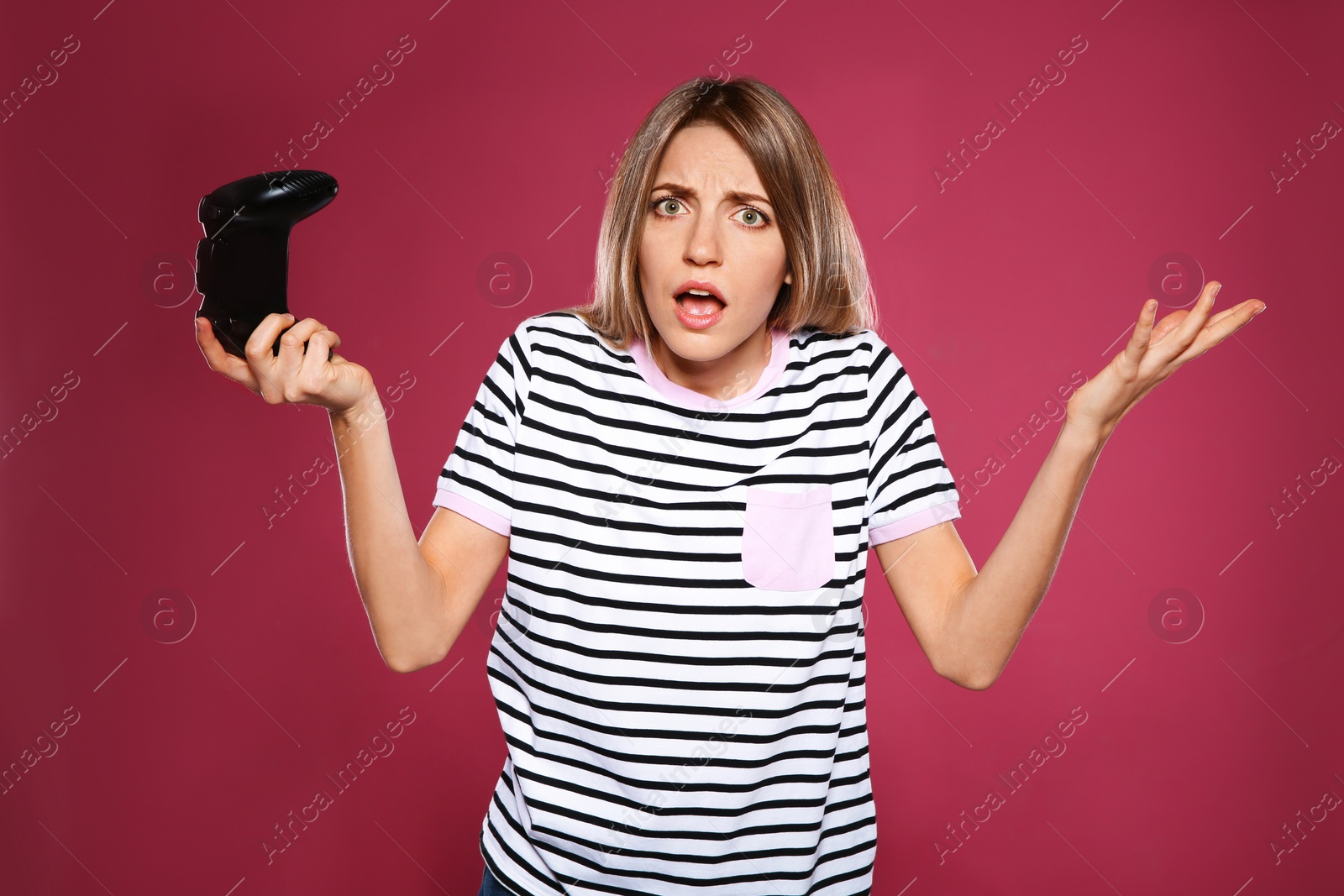 Photo of Emotional young woman playing video games with controller on color background