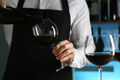 Photo of Bartender pouring wine into glass in restaurant, closeup