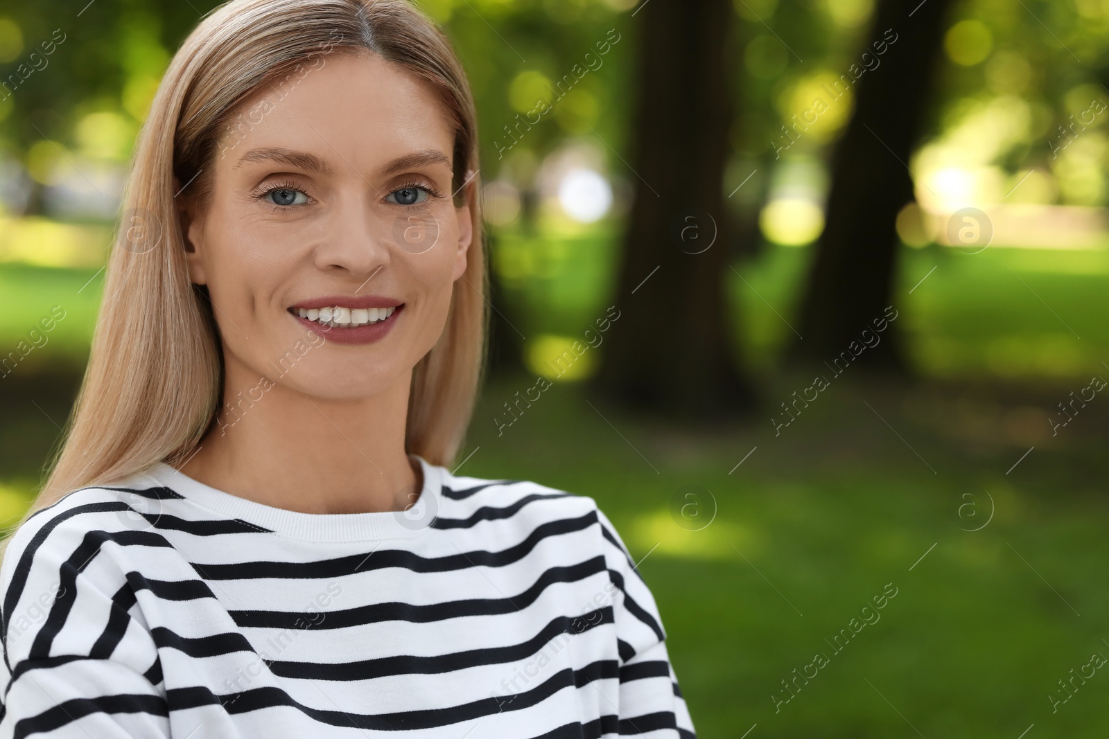 Photo of Portrait of happy woman in casual clothes outdoors. Space for text. Attractive lady smiling and posing for camera