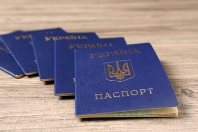 Many Ukrainian internal passports on wooden background, closeup