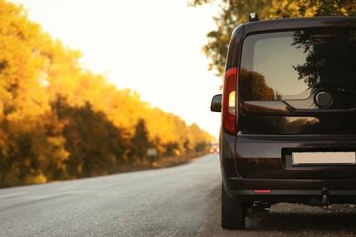 Photo of Car parked on country road. Space for text