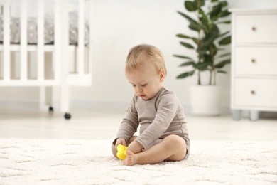 Photo of Children toys. Cute little boy playing with colorful toy on rug at home