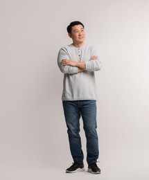 Photo of Full length portrait of happy man on light background. Space for text
