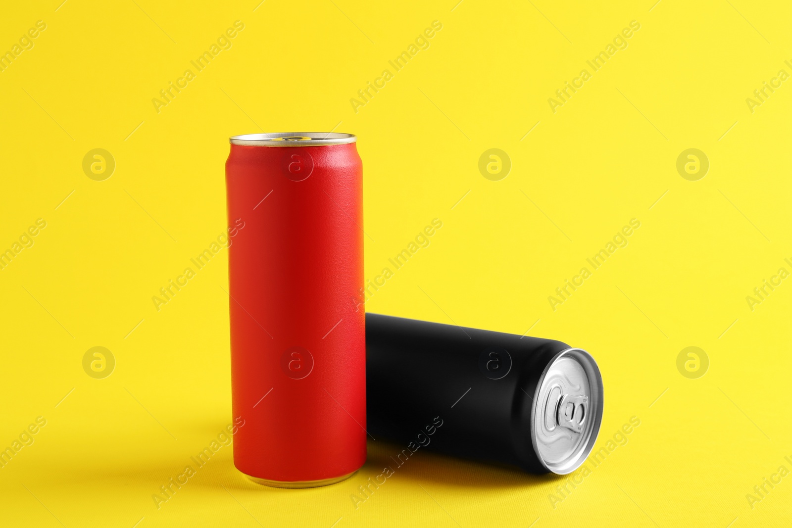 Photo of Energy drinks in colorful cans on yellow background