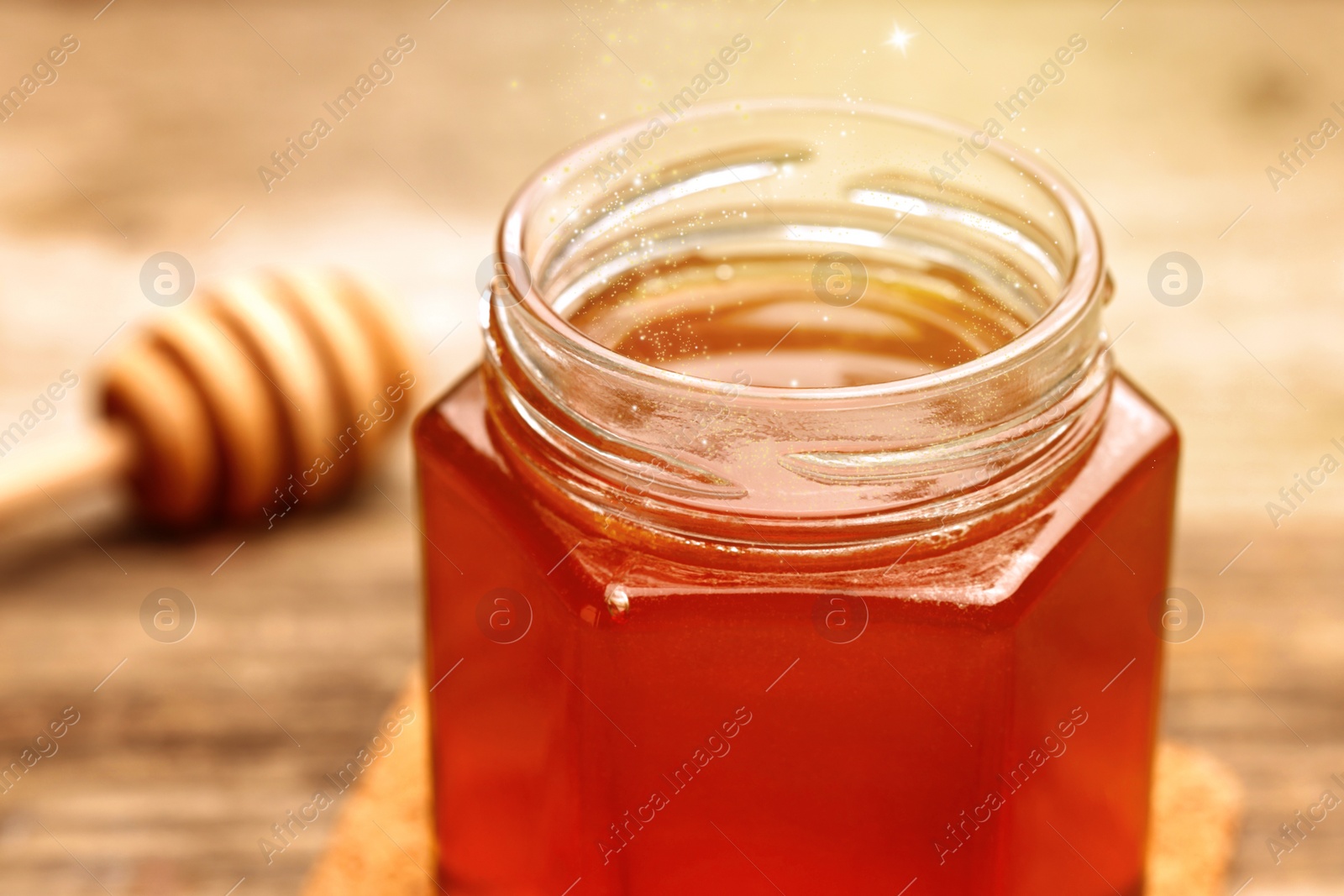 Image of Natural honey in glass jar under sunlight, closeup