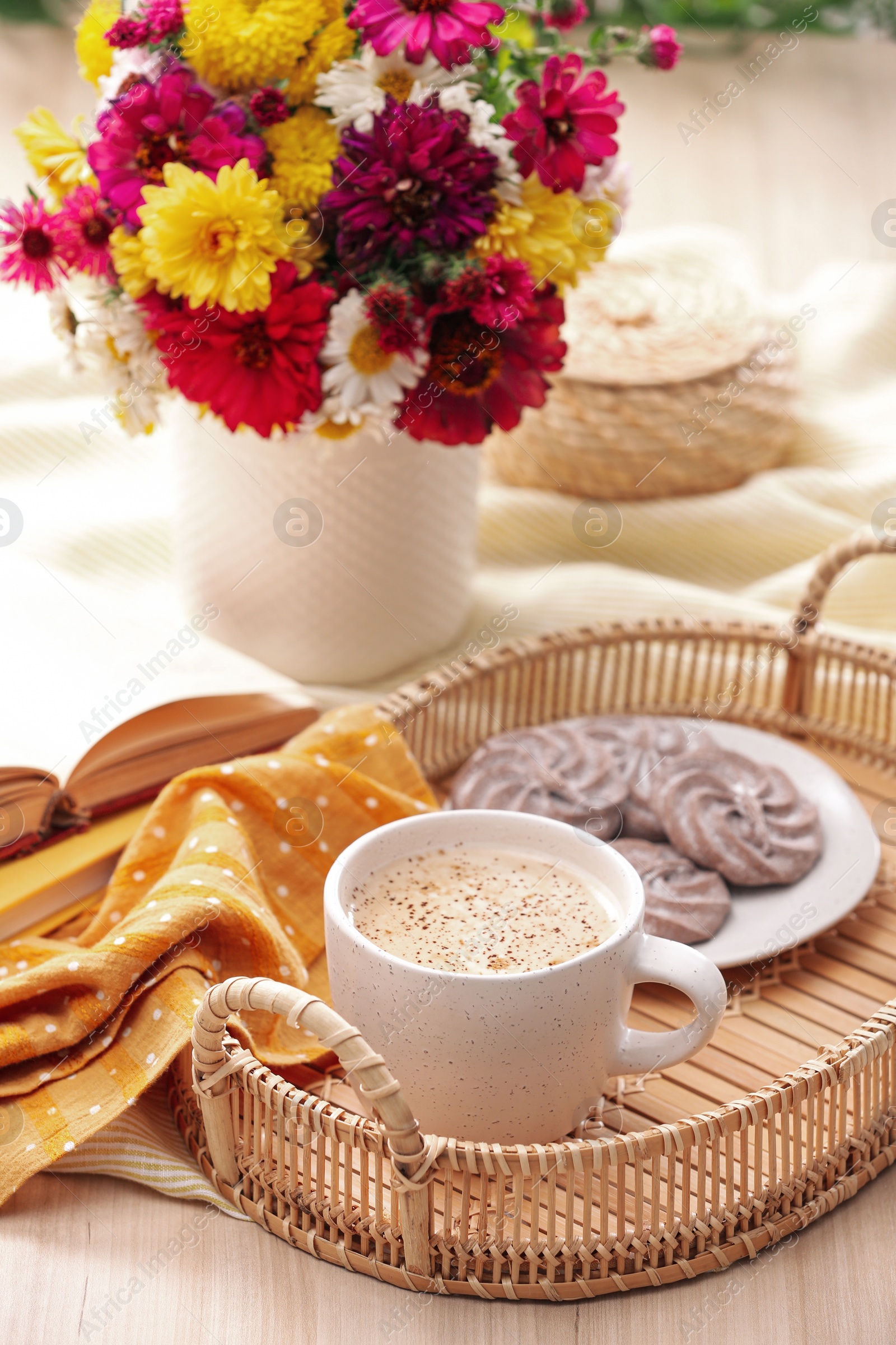 Photo of Cup of hot coffee, delicious cookies and beautiful bouquet on wooden table