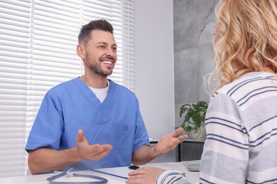 Doctor consulting patient at table in clinic