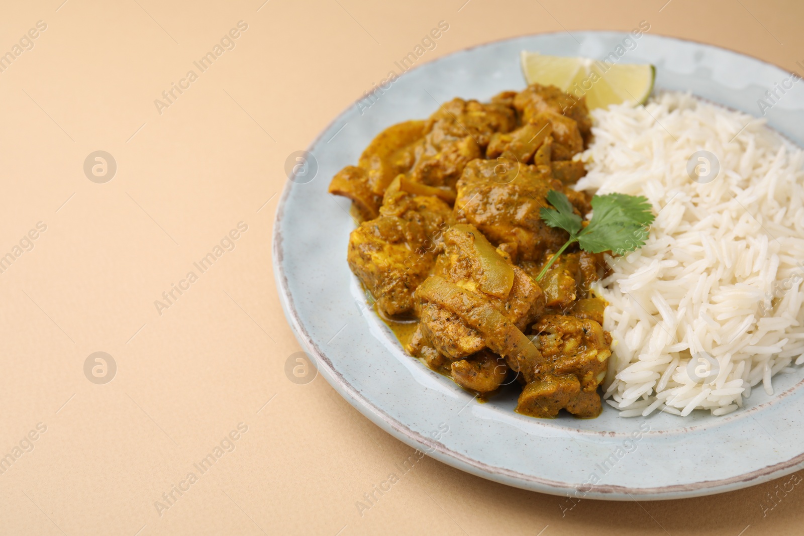 Photo of Delicious chicken curry with rice on beige background, closeup. Space for text