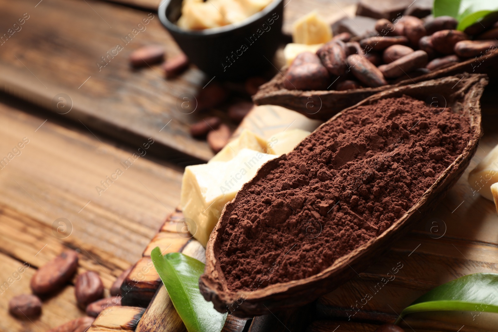 Photo of Composition with organic cocoa butter on wooden table, closeup