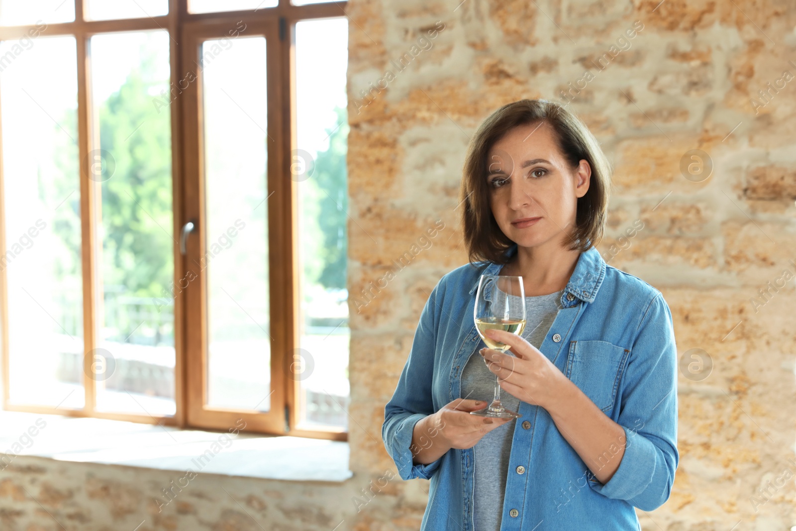 Photo of Woman with glass of white wine indoors