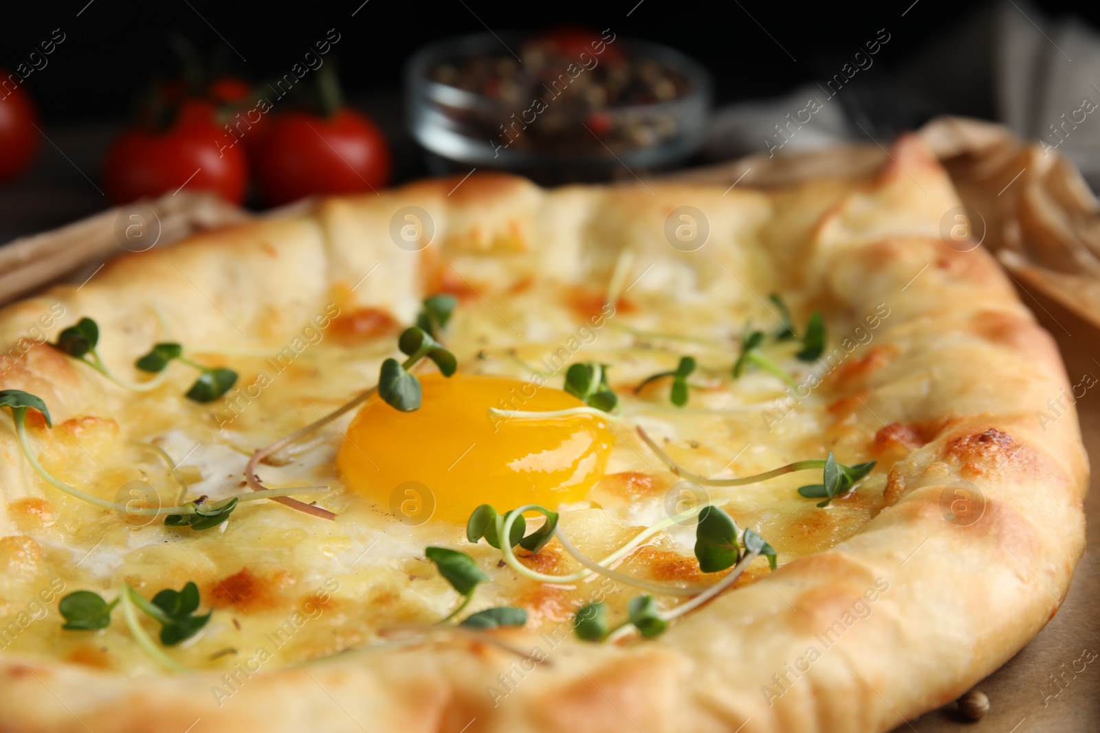 Photo of Fresh delicious Adjarian khachapuri with microgreens, closeup