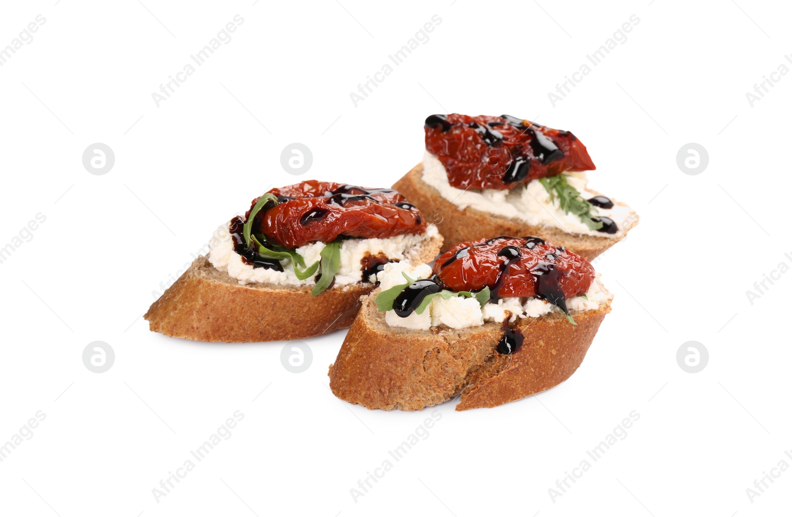 Photo of Delicious bruschettas with sun-dried tomatoes, cream cheese and balsamic vinegar isolated on white