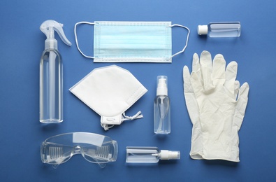 Photo of Flat lay composition with medical gloves, masks and hand sanitizer on blue background