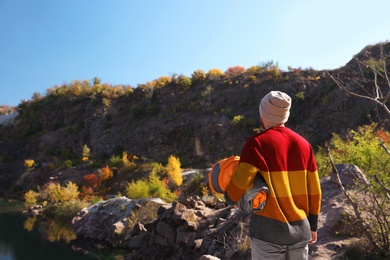 Male camper with sleeping bag near beautiful lake. Space for text