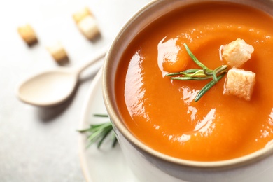 Photo of Mug of tasty sweet potato soup on table, closeup