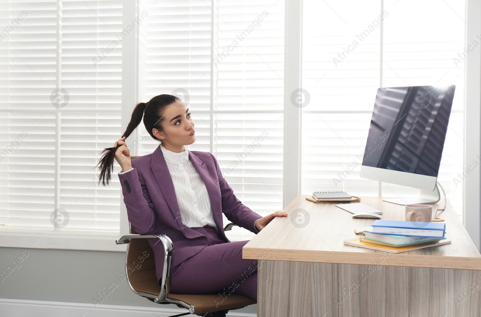 Photo of Lazy employee wasting time at table in office