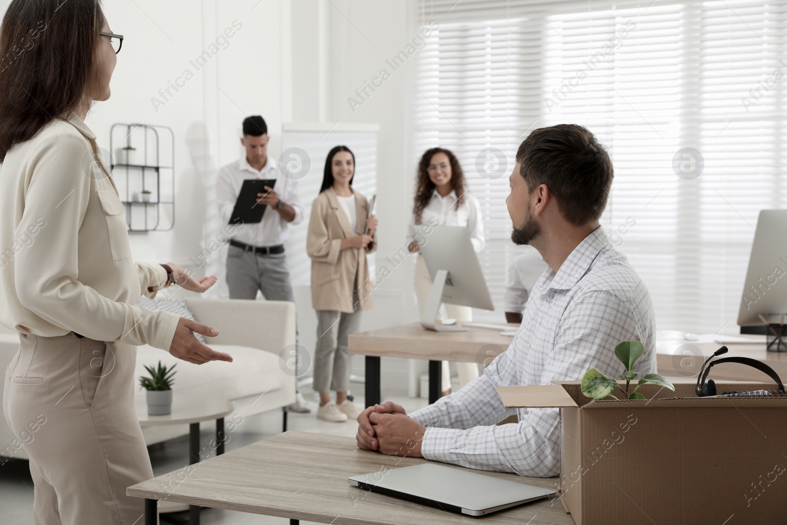 Photo of Boss introducing new employee to coworkers in office