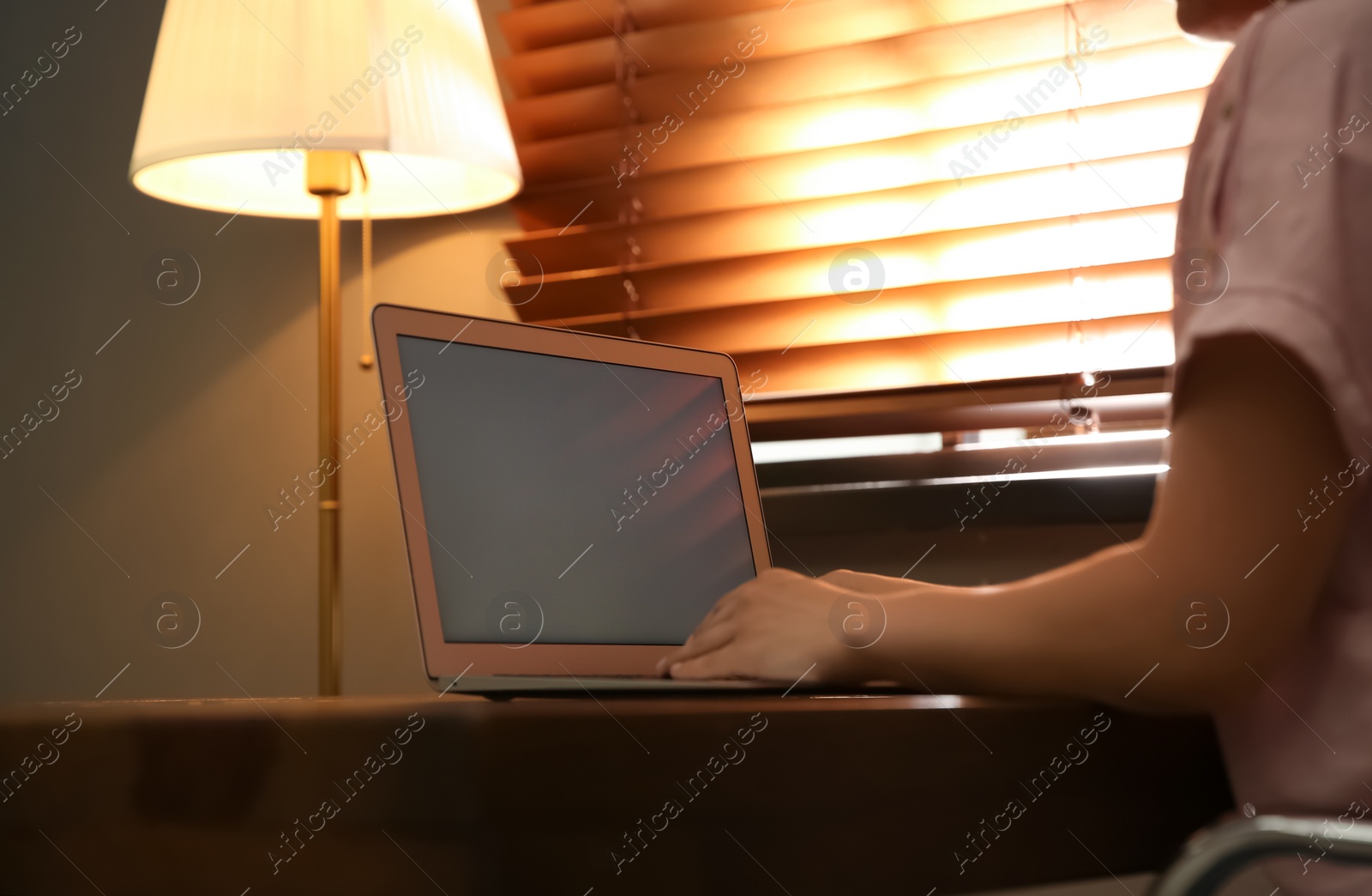 Photo of Woman working with modern laptop at wooden table, closeup