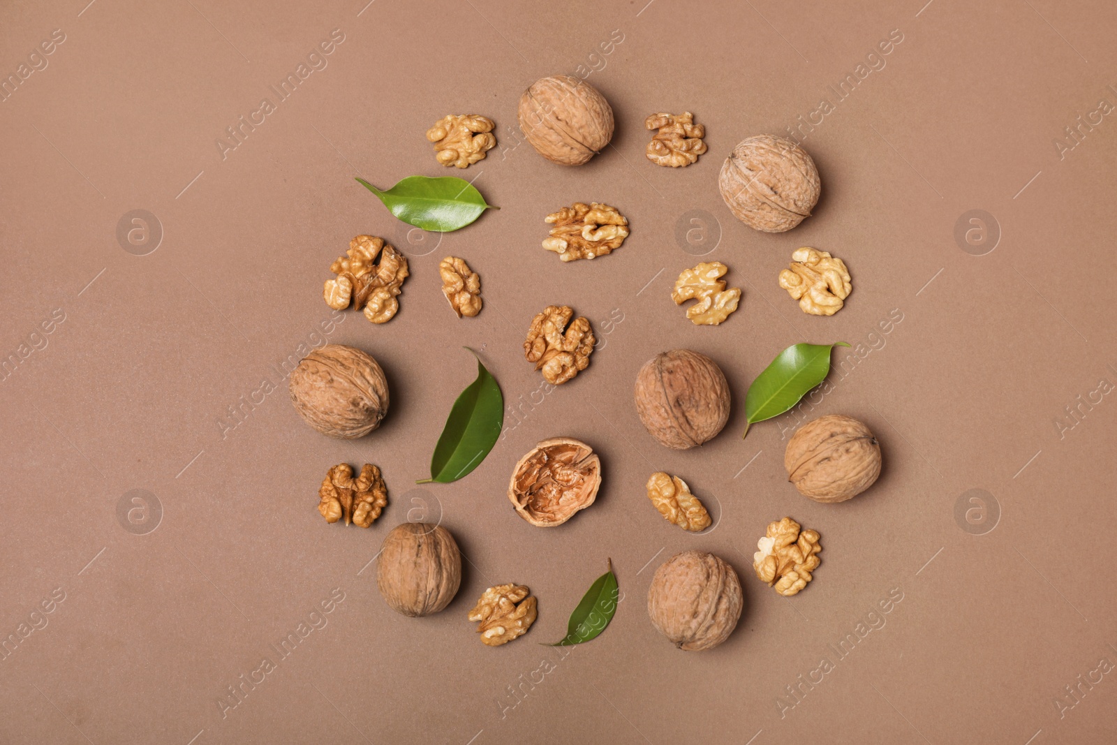 Photo of Flat lay composition with walnuts and leaves on color background, flat lay