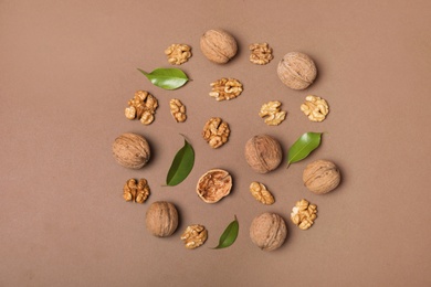 Flat lay composition with walnuts and leaves on color background, flat lay