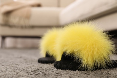 Photo of Yellow warm slippers on floor in room