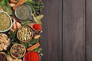 Photo of Different natural spices and herbs on wooden table, flat lay. Space for text