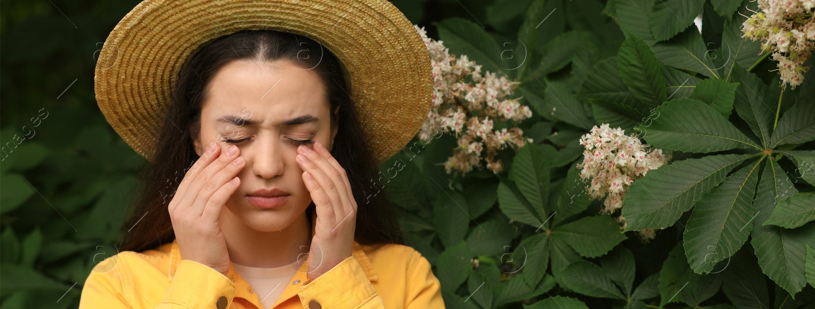 Image of Woman suffering from seasonal spring allergy near tree in park. Banner design with space for text