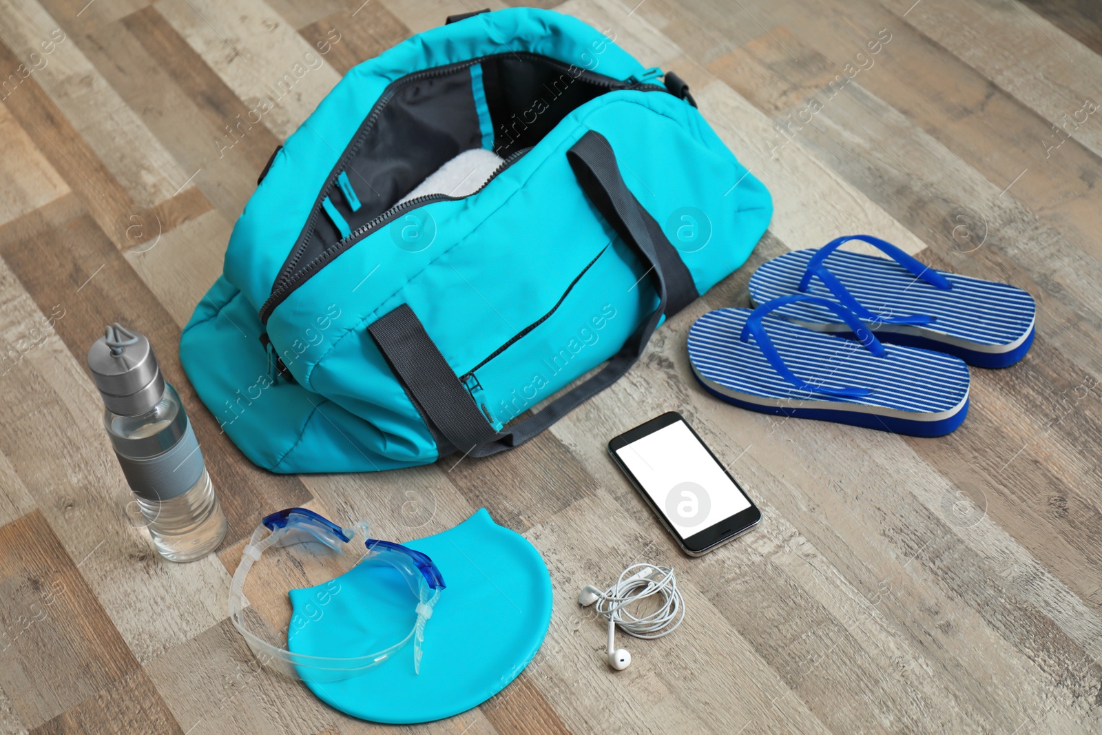 Photo of Sports bag and equipment for swimming pool on wooden floor