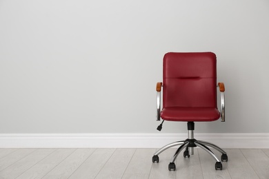 Photo of Comfortable office chair near light wall indoors. Space for text