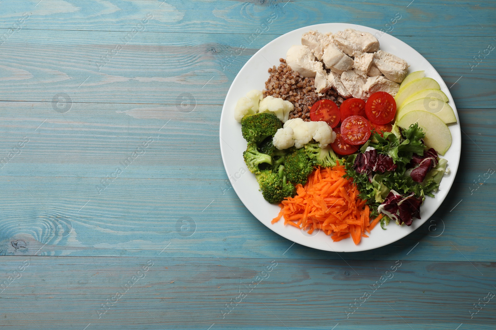 Photo of Balanced diet and healthy foods. Plate with different delicious products on blue wooden table, top view. Space for text