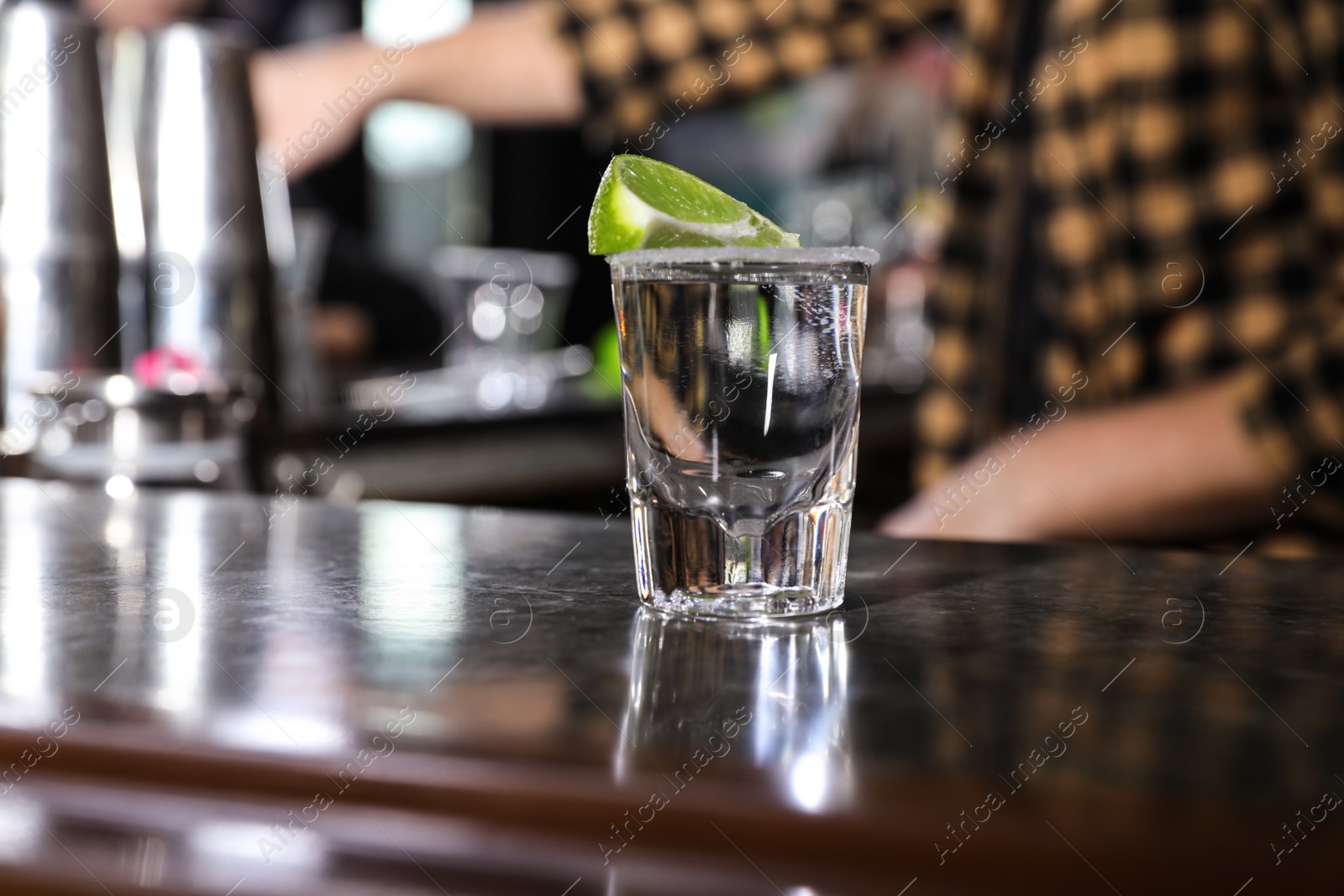 Photo of Mexican Tequila shot with lime slice on bar counter