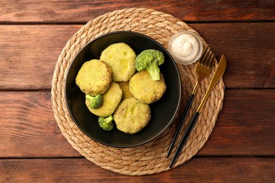 Tasty vegan cutlets served with sauce on wooden table, top view