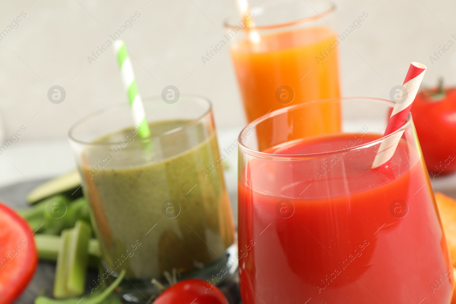 Photo of Delicious vegetable juices and fresh ingredients on table, closeup