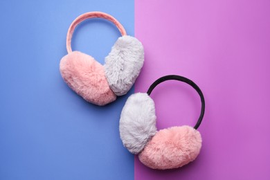 Stylish winter earmuffs on color background, flat lay