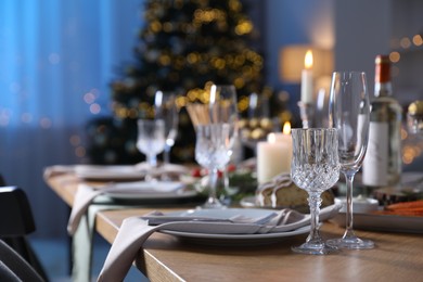 Photo of Christmas table setting with festive decor and dishware indoors