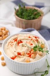 Photo of Delicious hummus with chickpeas and paprika served on white table, closeup