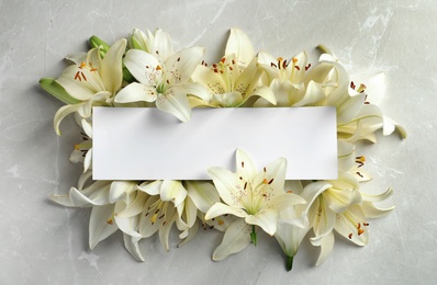 Photo of Flat lay composition with lily flowers and blank card on light background