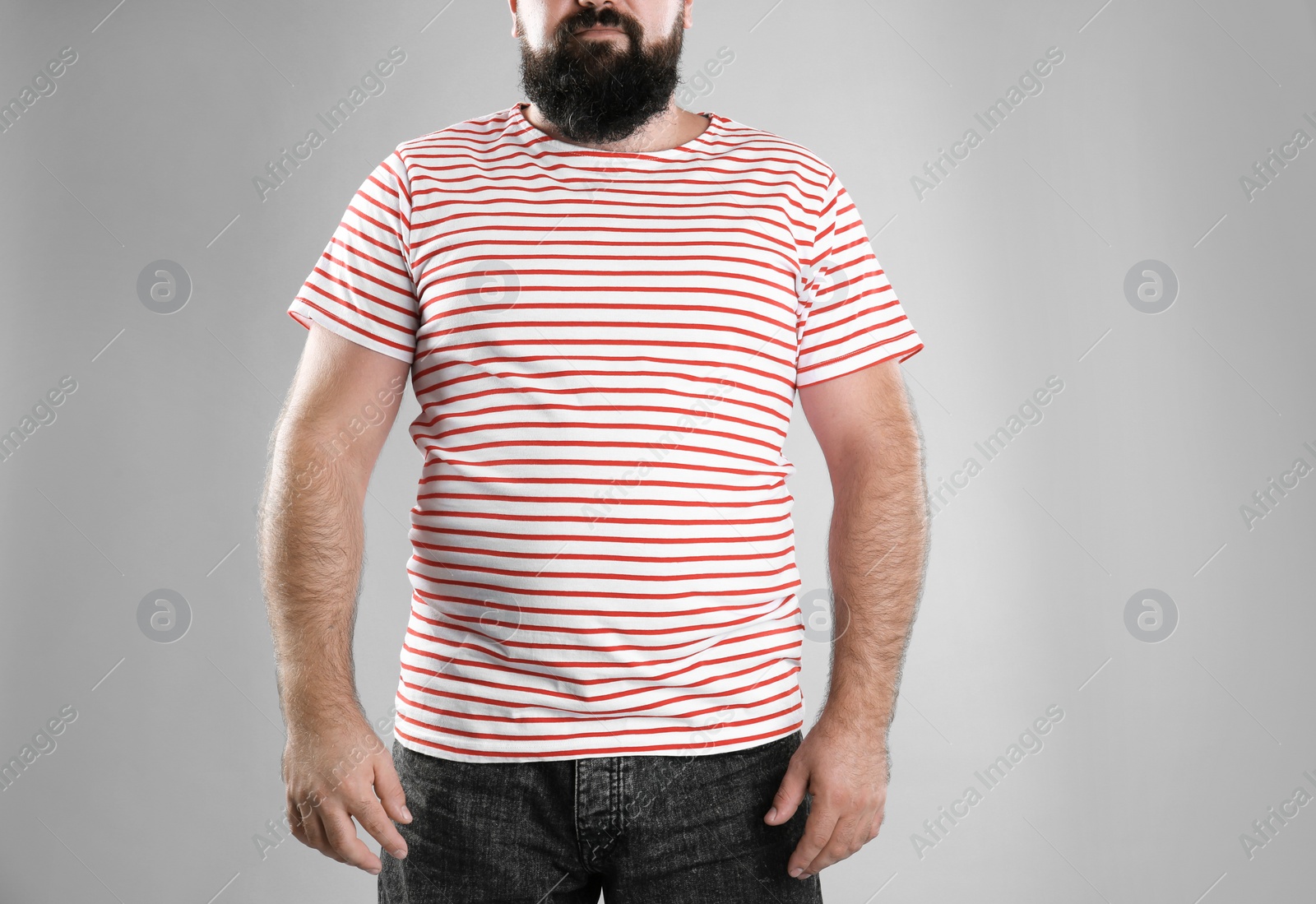 Photo of Fat man on grey background, closeup. Weight loss