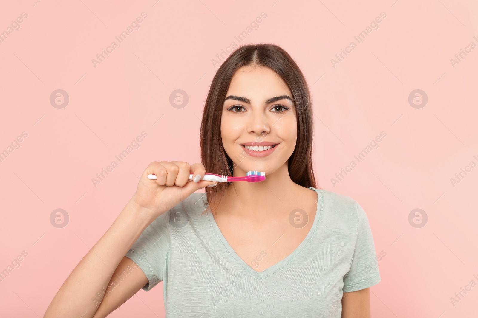 Photo of Beautiful woman brushing teeth on color background