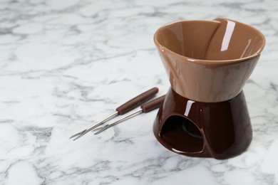 Photo of Fondue set on white marble table, space for text